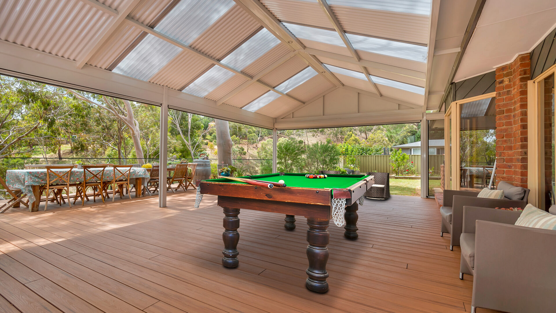 Massive decking with shaded by a gable structure and a pool table in the middle